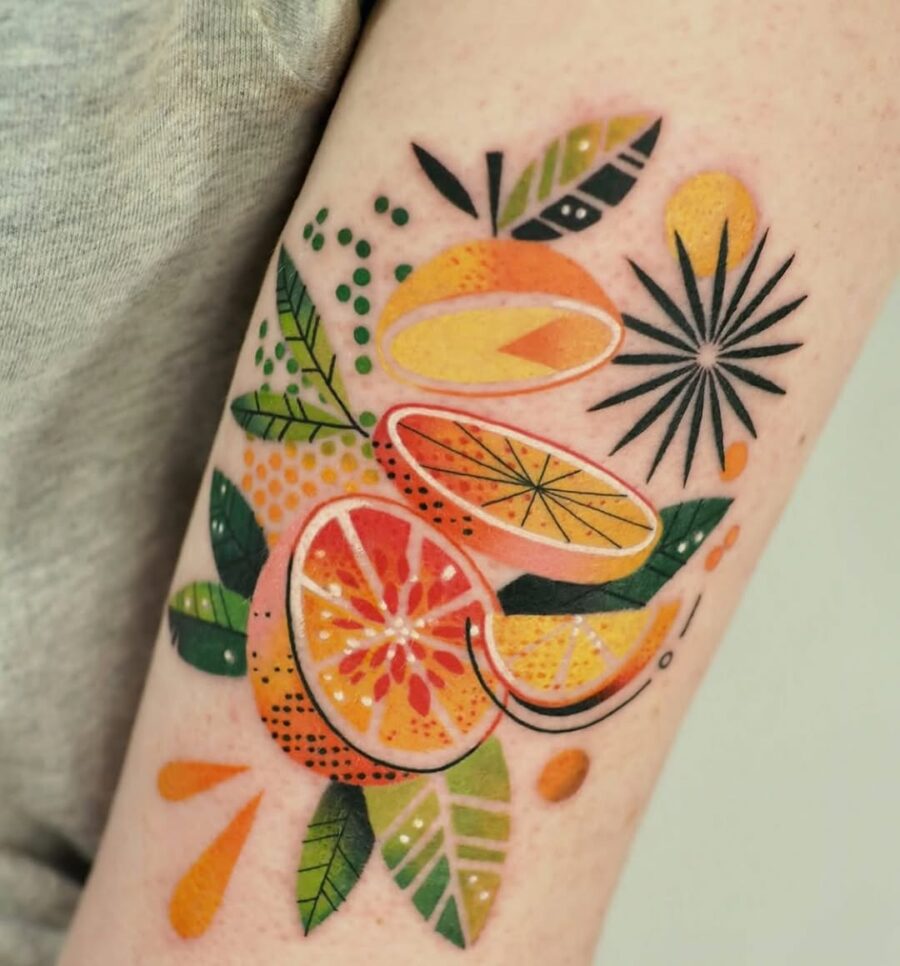 Vibrant Orange Fruit Tattoo with Leaf Details Tattoo on skin