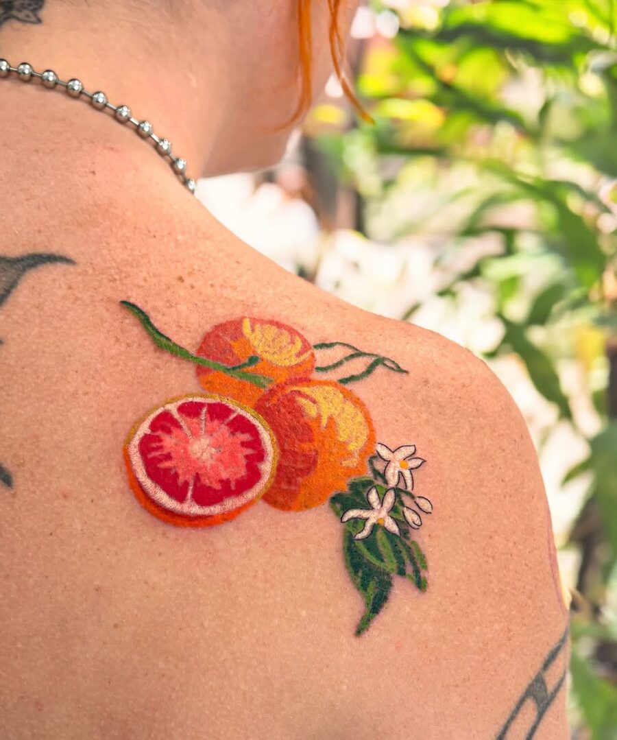 Vibrant orange tattoo with delicate floral accents Tattoo on skin