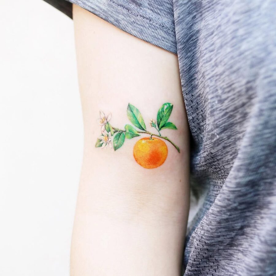 Vibrant orange tattoo with delicate floral accents Tattoo on skin