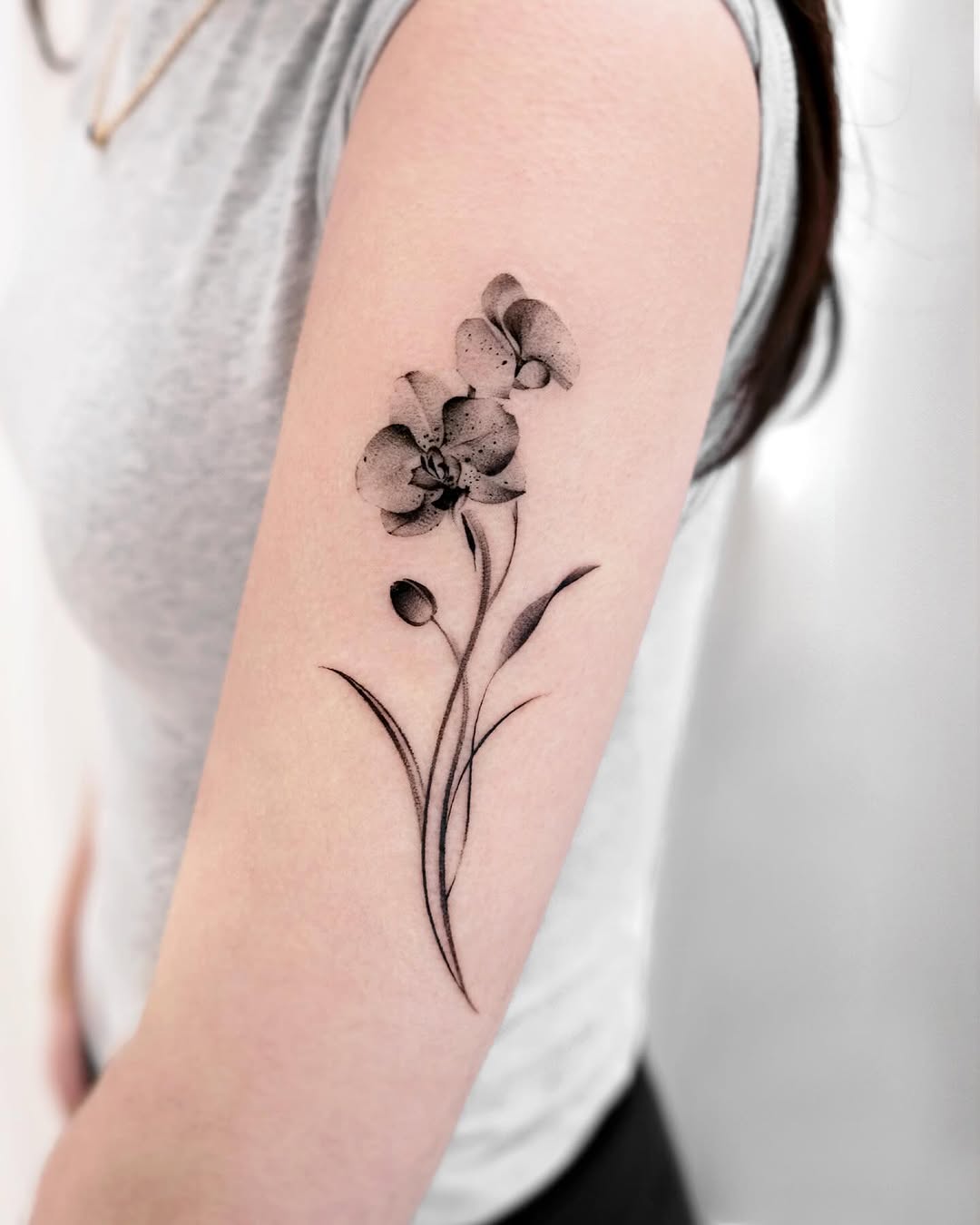 Elegant black and gray orchid tattoo on arm Tattoo on skin