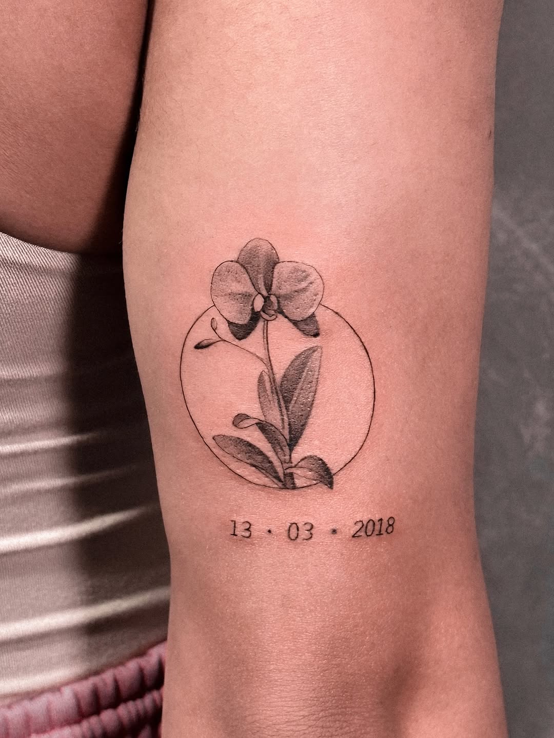 Elegant minimalistic orchid tattoo with date Tattoo on skin