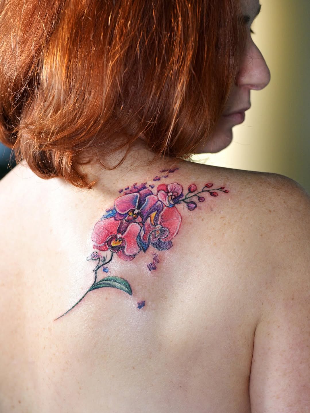 Elegant orchid tattoo design on shoulder blade Tattoo on skin