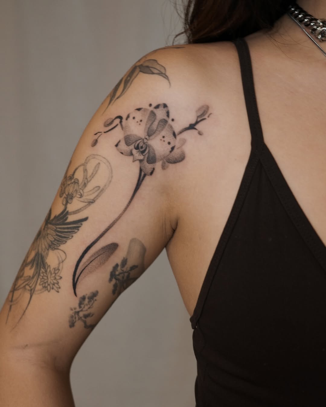 Elegant orchid tattoo on the shoulder Tattoo on skin