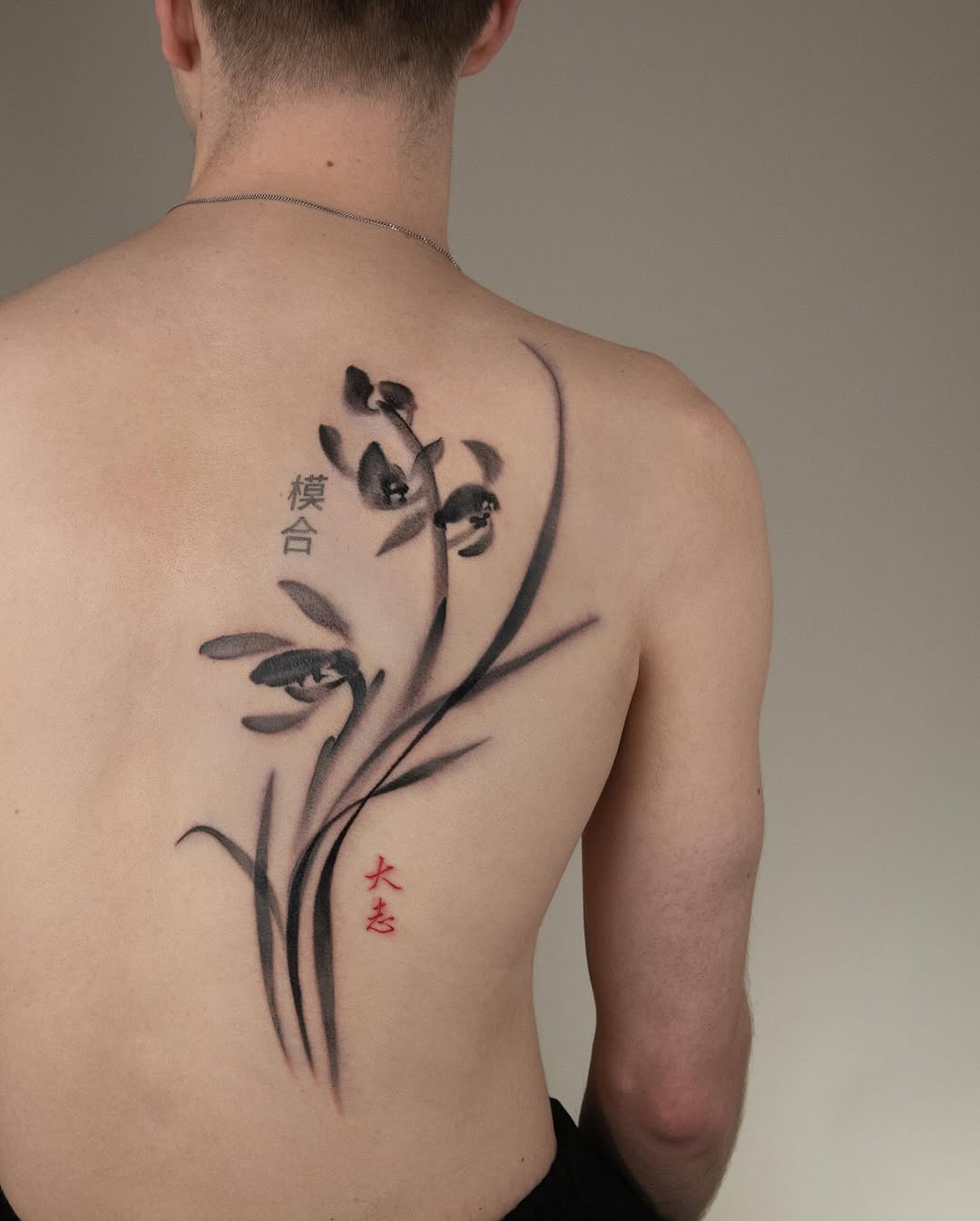 Elegant orchid tattoo with bold black ink. Tattoo on skin