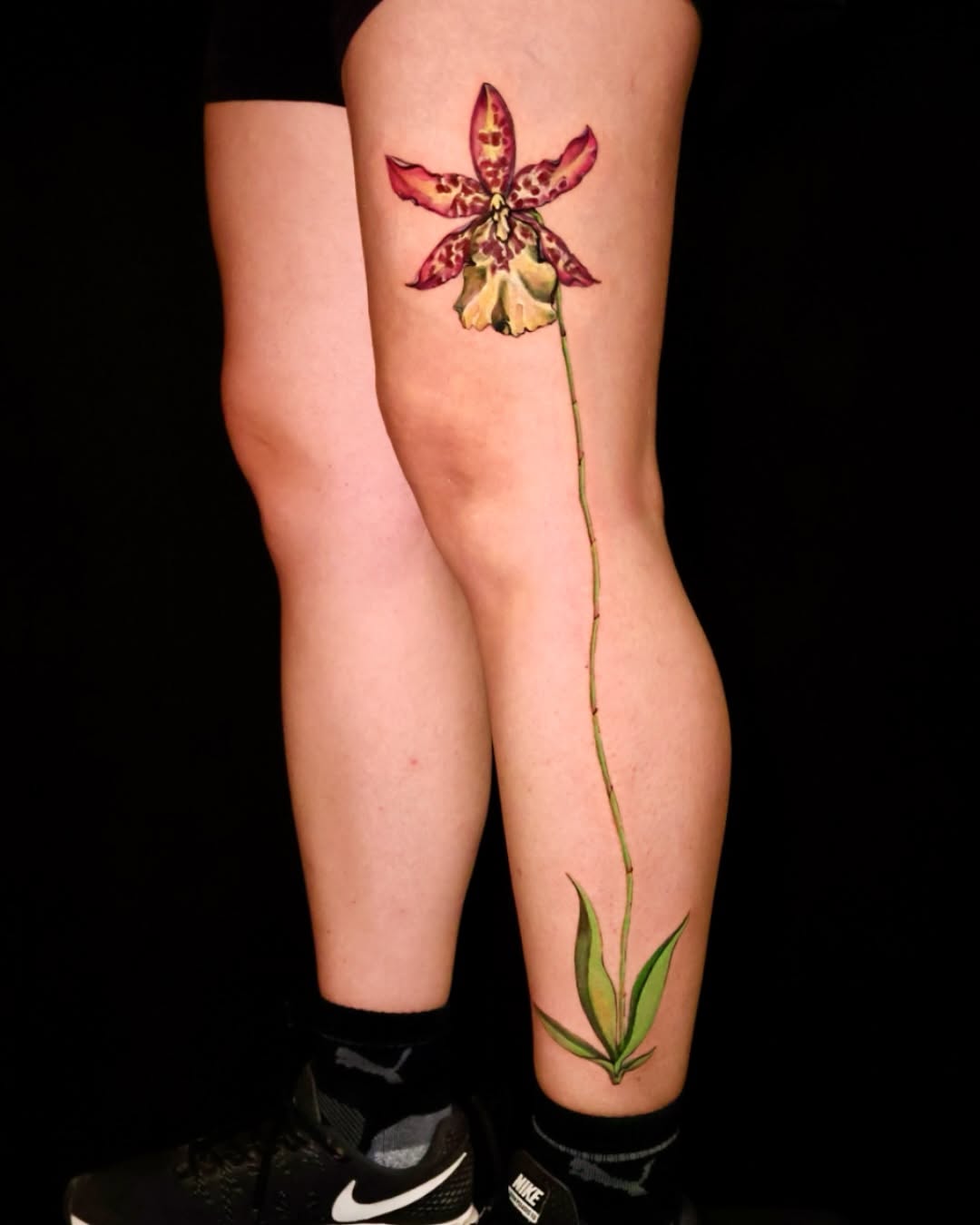 Stunning orchid tattoo gracing the leg Tattoo on skin