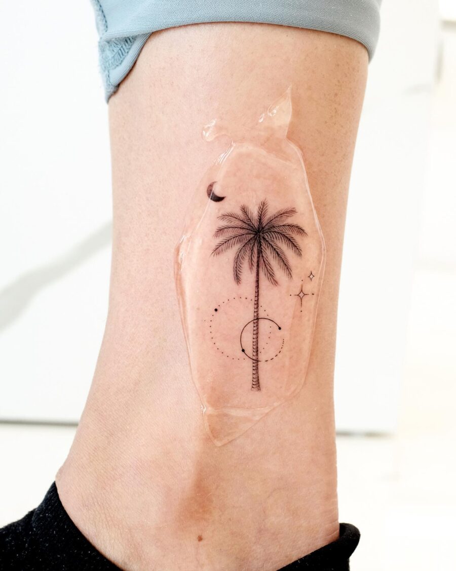 Elegant palm tree tattoo on the ankle. Tattoo on skin