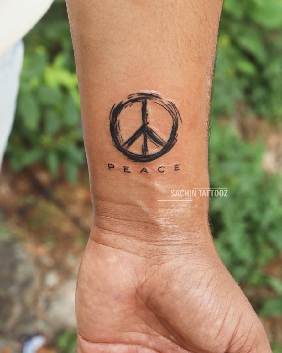 Minimalist peace symbol tattoo on wrist Tattoo on skin