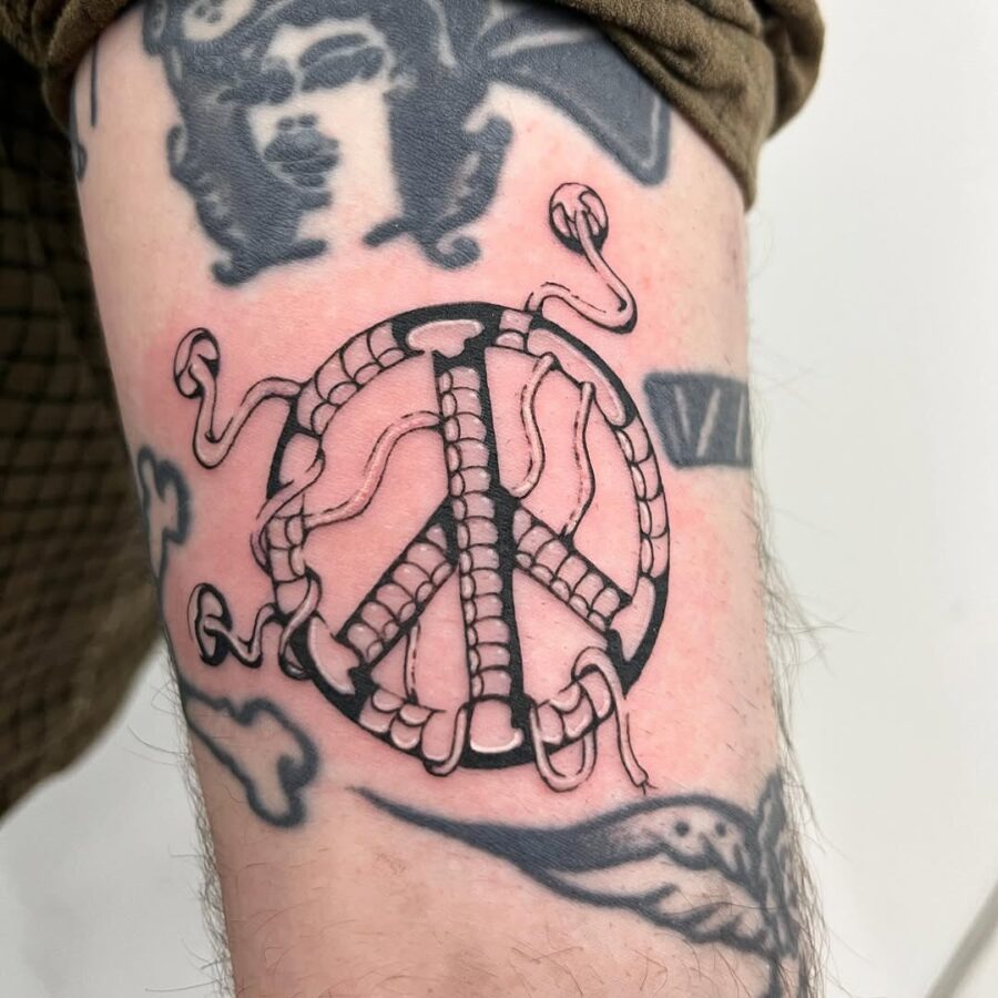 Unique peace symbol intertwined with serpents Tattoo on skin