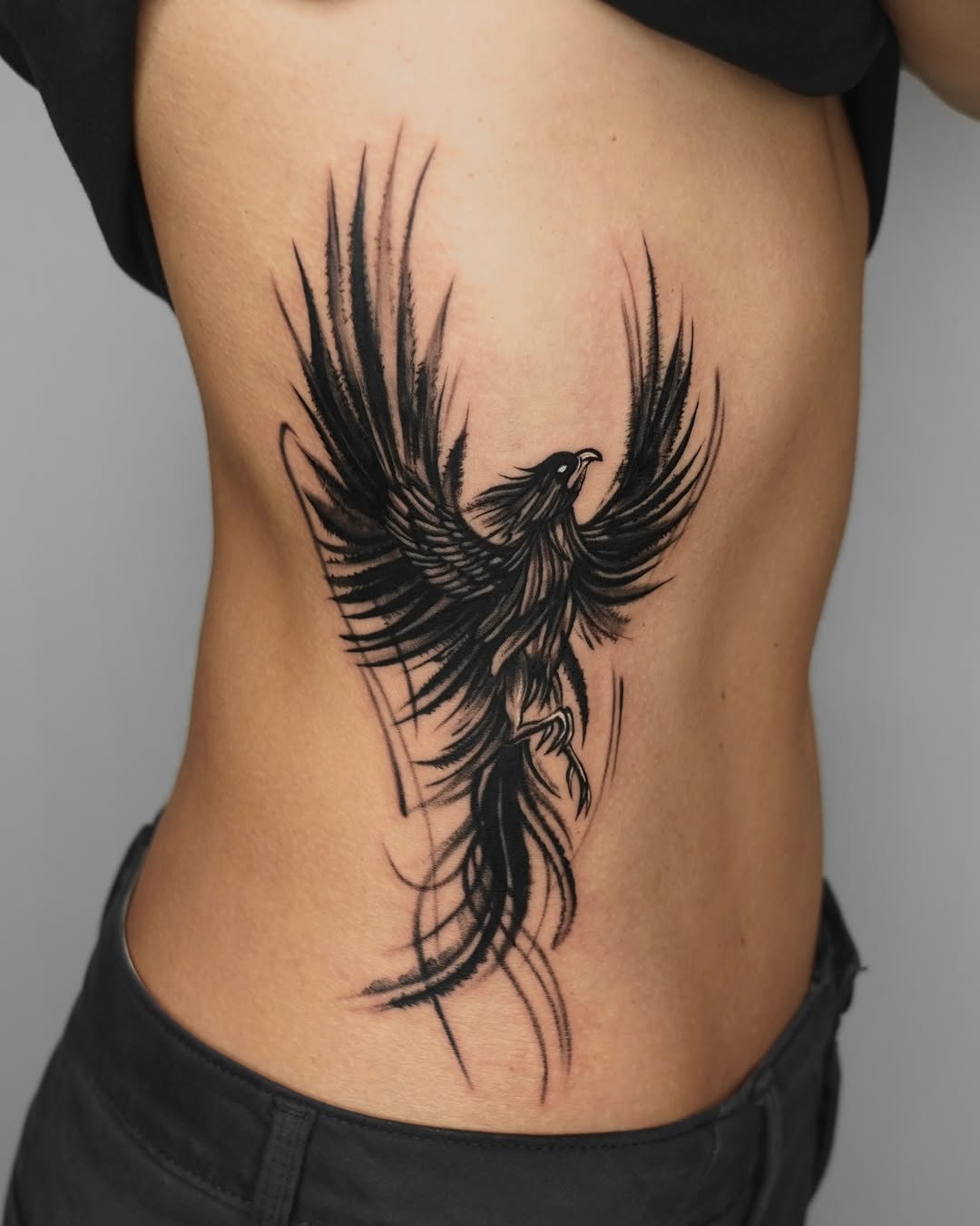 Dynamic phoenix tattoo design on side body Tattoo on skin