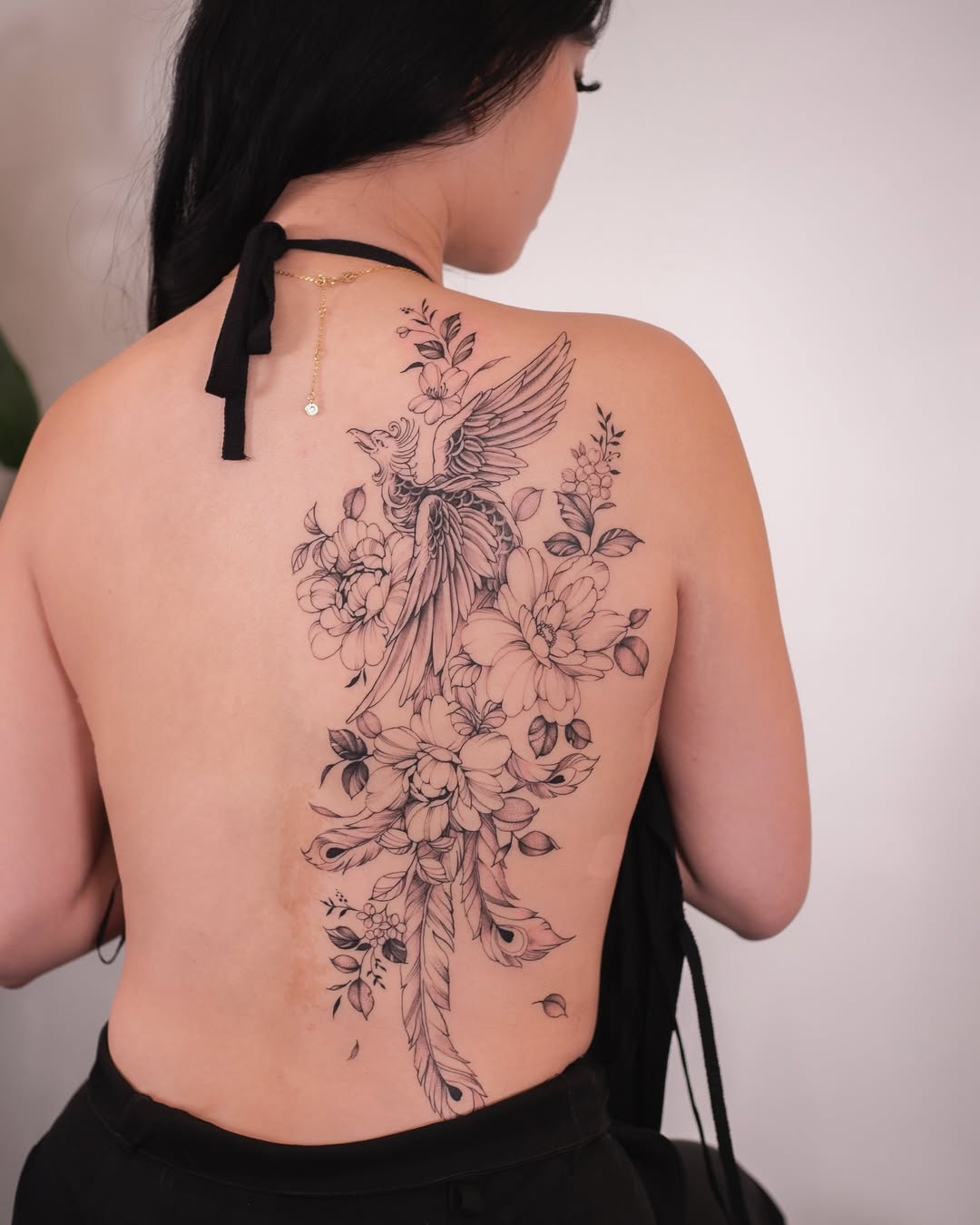 Elegant phoenix tattoo with floral elements Tattoo on skin
