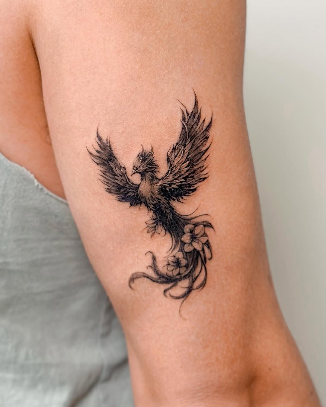 Elegant phoenix tattoo with floral elements Tattoo on skin