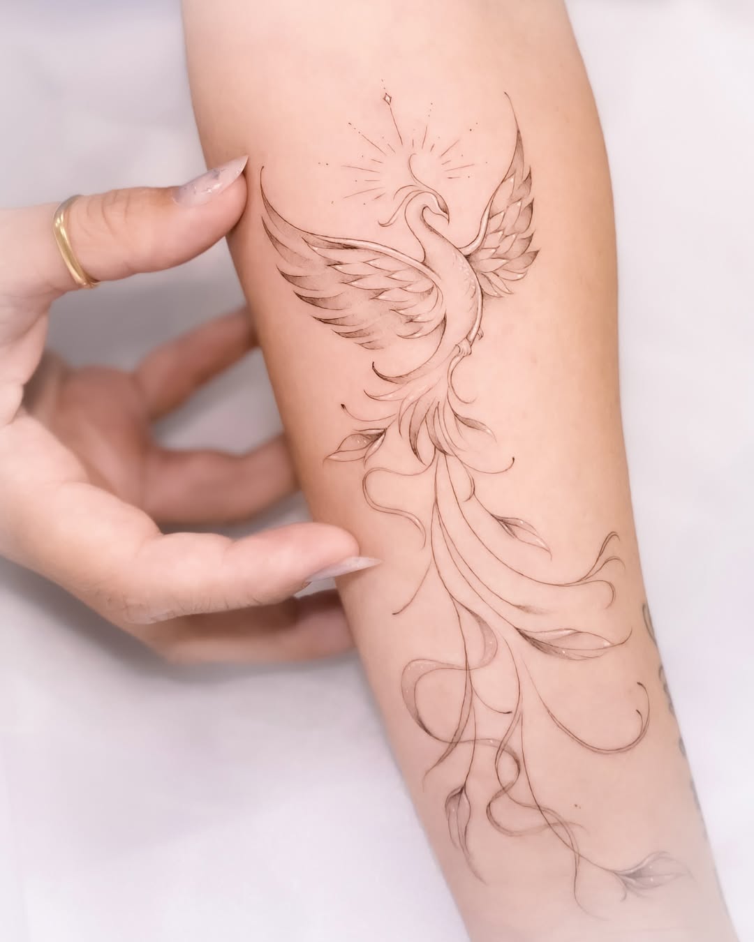 Elegant phoenix tattoo with flowing lines Tattoo on skin
