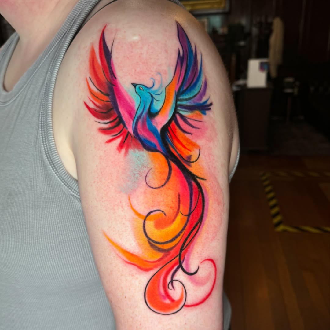 Vibrant Phoenix Tattoo with Colorful Flames Tattoo on skin