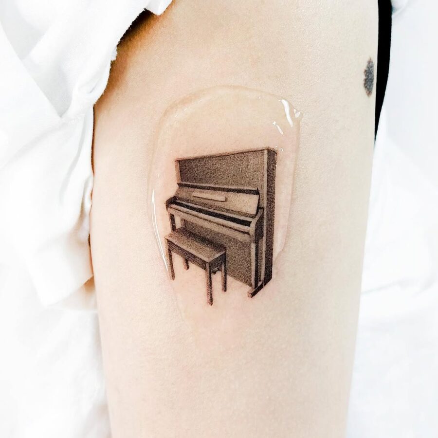 Elegant piano tattoo in realistic style Tattoo on skin