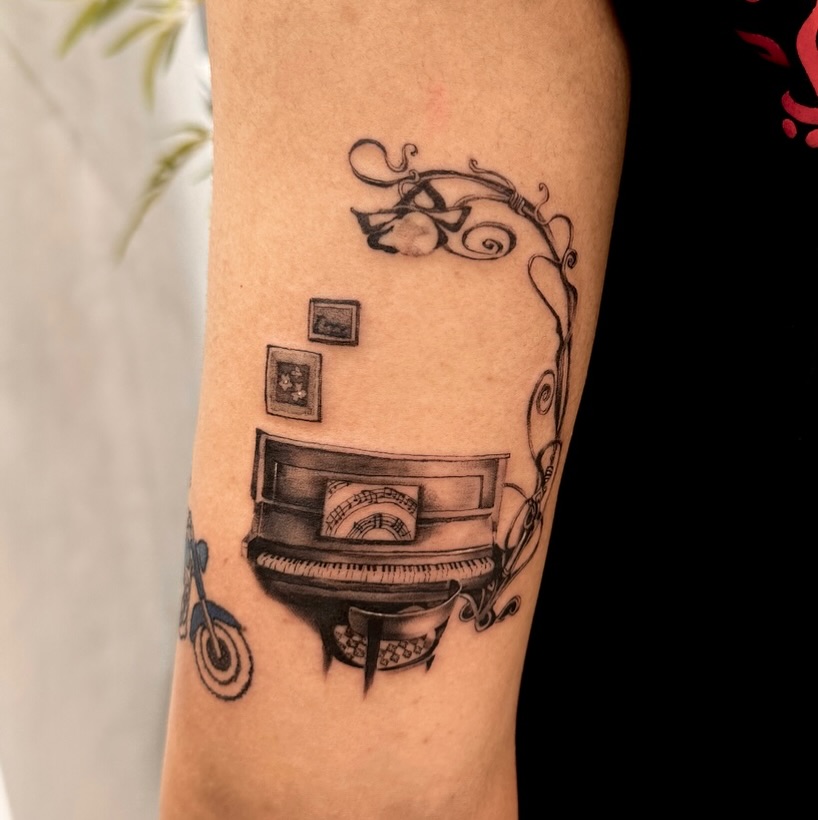 Elegant piano tattoo with artistic flourishes Tattoo on skin