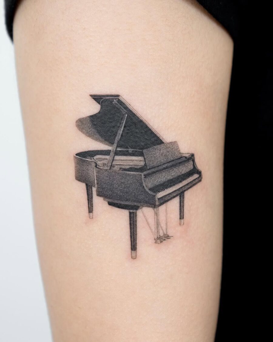 Sleek Grand Piano Tattoo on Upper Arm Tattoo on skin