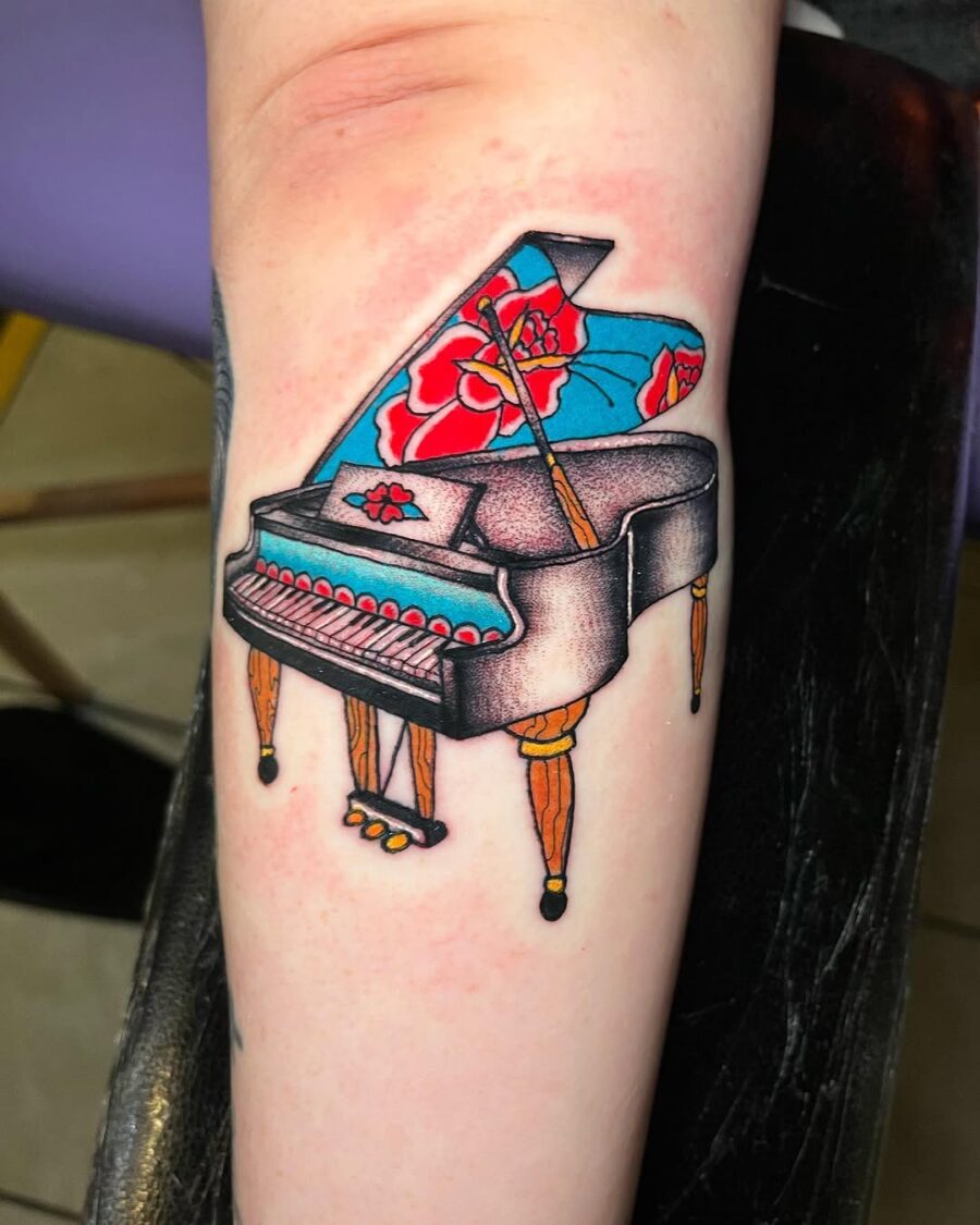 Vibrant grand piano tattoo with floral elements Tattoo on skin