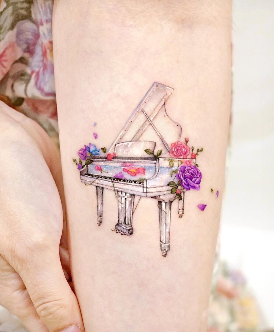 Whimsical piano tattoo adorned with flowers Tattoo on skin