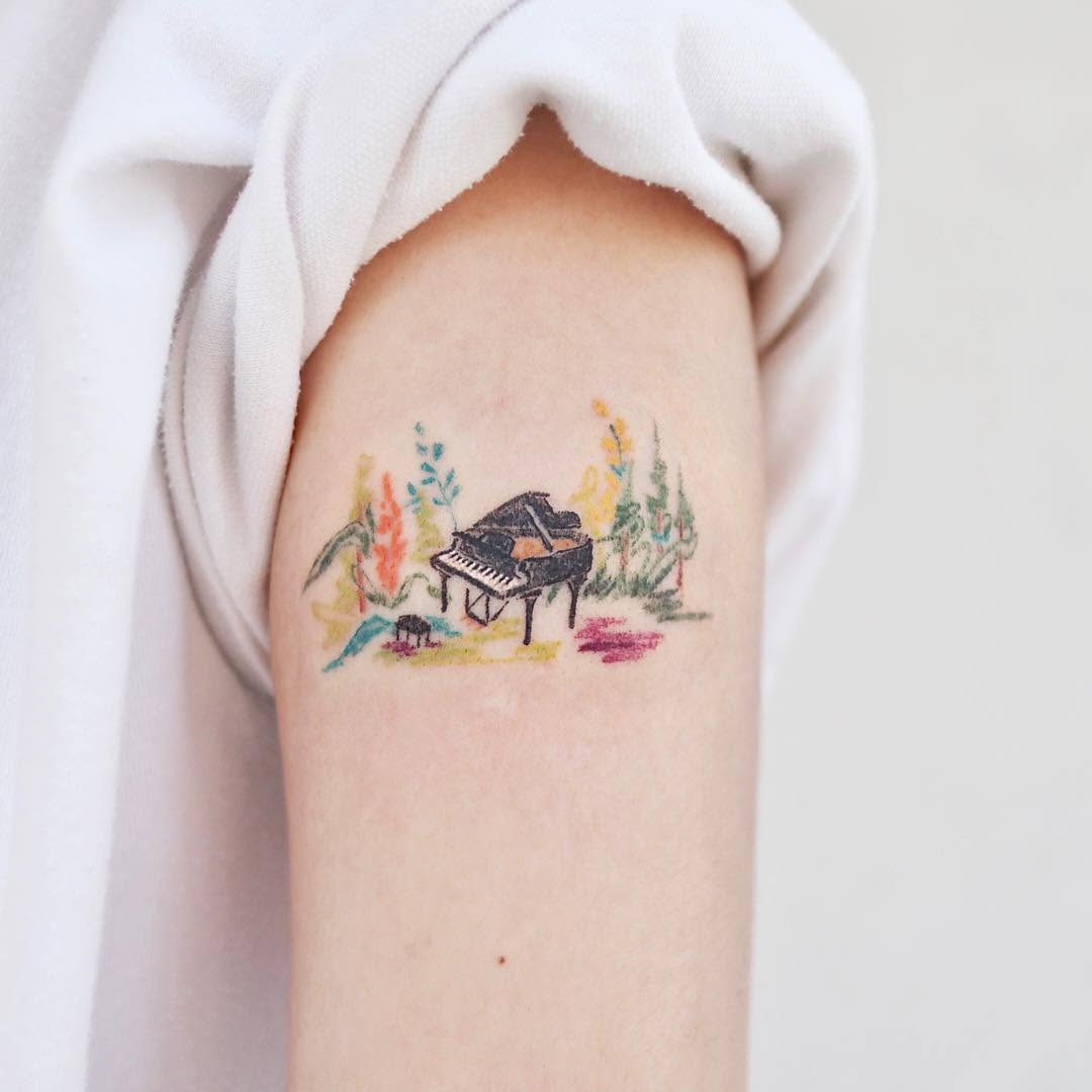 Whimsical piano tattoo with vibrant floral elements Tattoo on skin