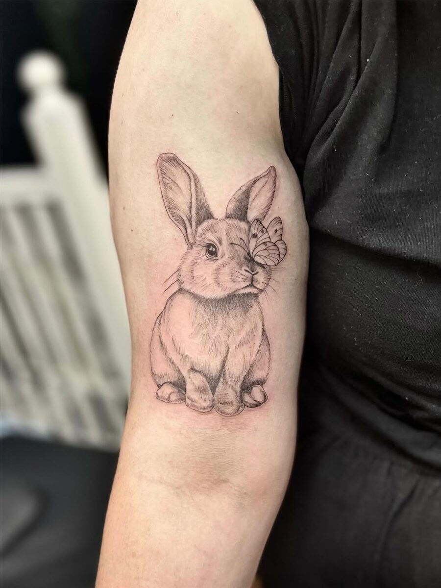 Adorable rabbit tattoo with butterfly detail Tattoo on skin