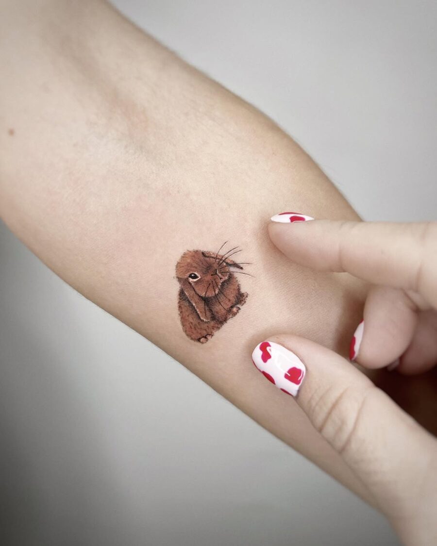 Charming brown rabbit tattoo on forearm Tattoo on skin
