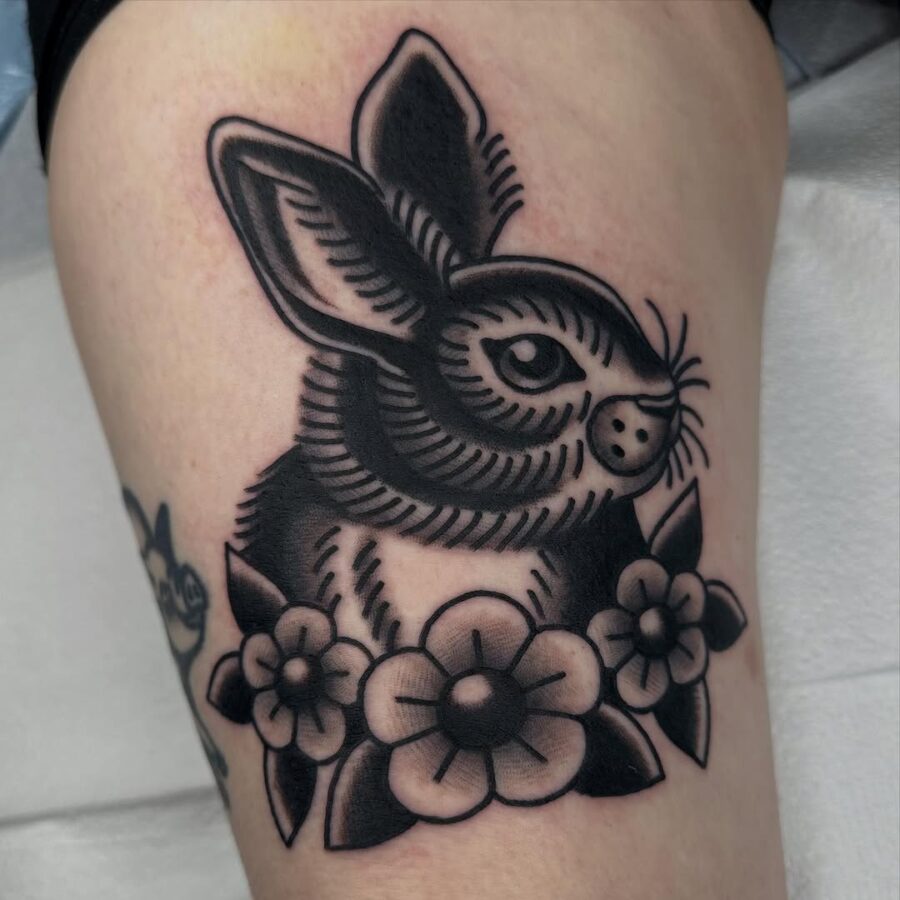 Charming rabbit tattoo surrounded by flowers Tattoo on skin