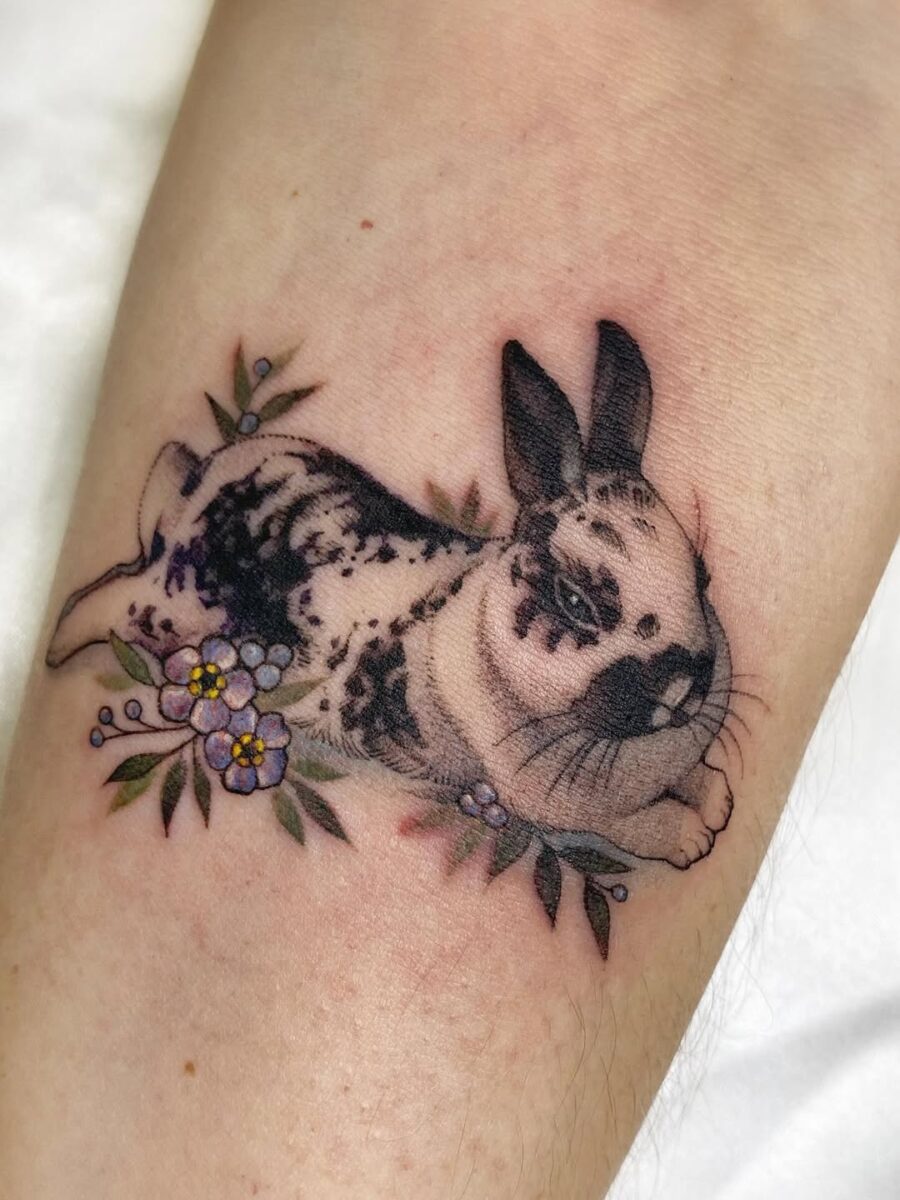 Charming rabbit tattoo with floral accents Tattoo on skin