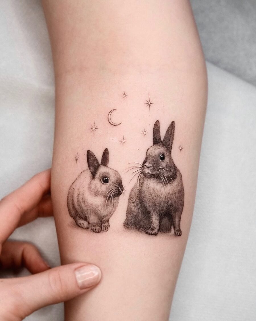 Charming rabbits surrounded by stars and moon Tattoo on skin
