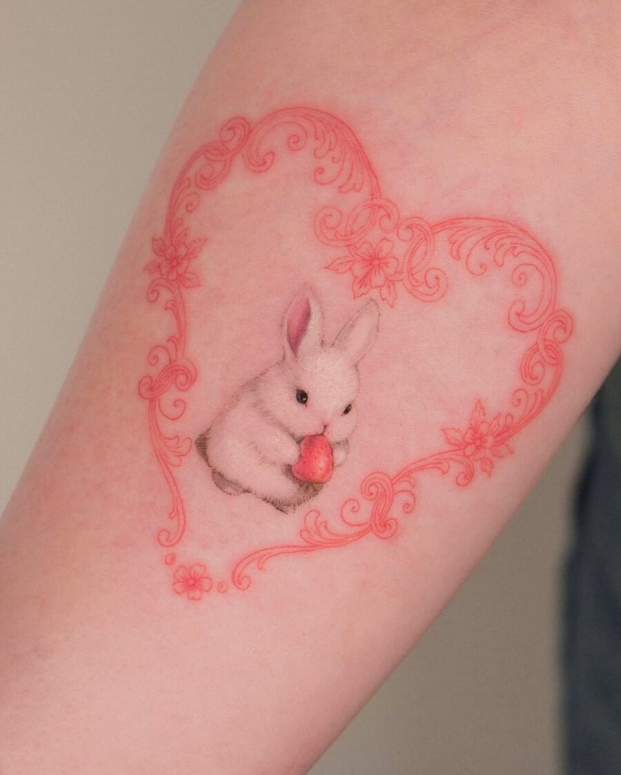 Delicate rabbit tattoo within floral heart frame Tattoo on skin