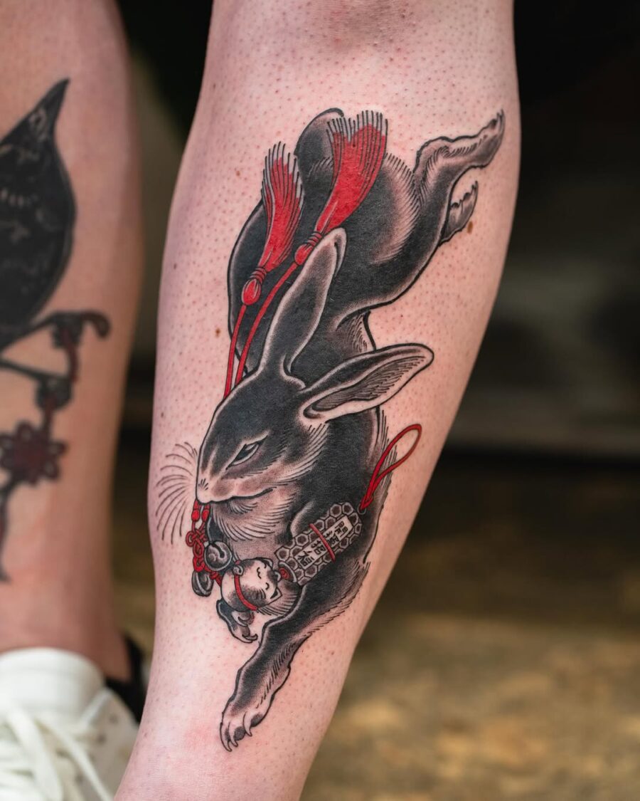 Dynamic rabbit tattoo with vibrant red accents Tattoo on skin