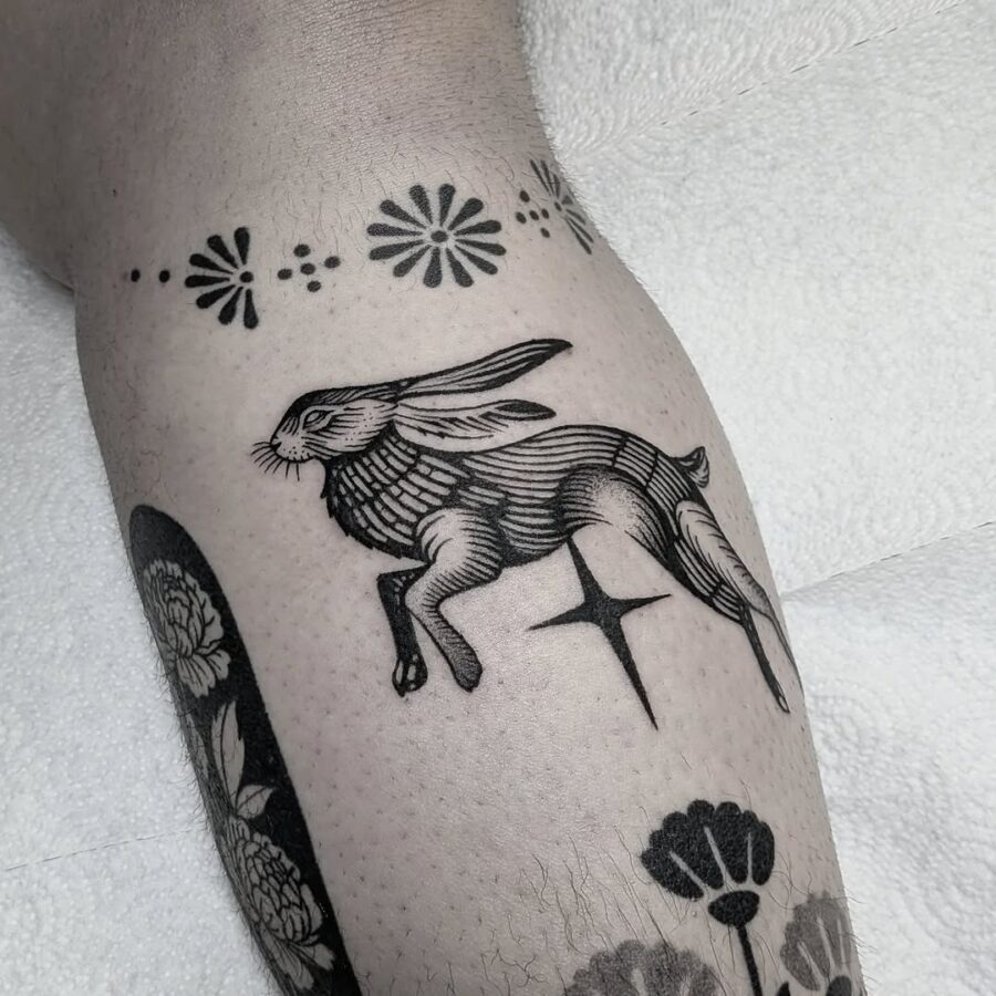 Elegant leaping rabbit tattoo in black ink Tattoo on skin