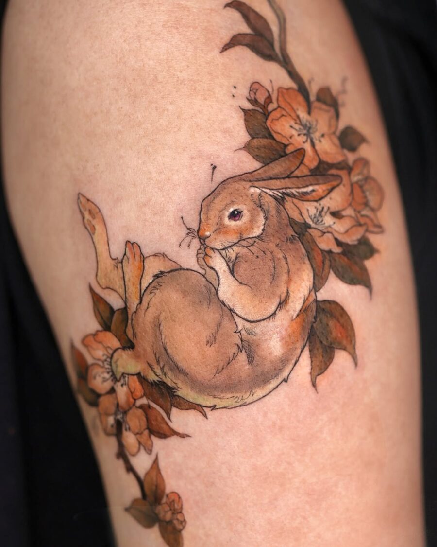 Whimsical rabbit tattoo surrounded by blooms Tattoo on skin