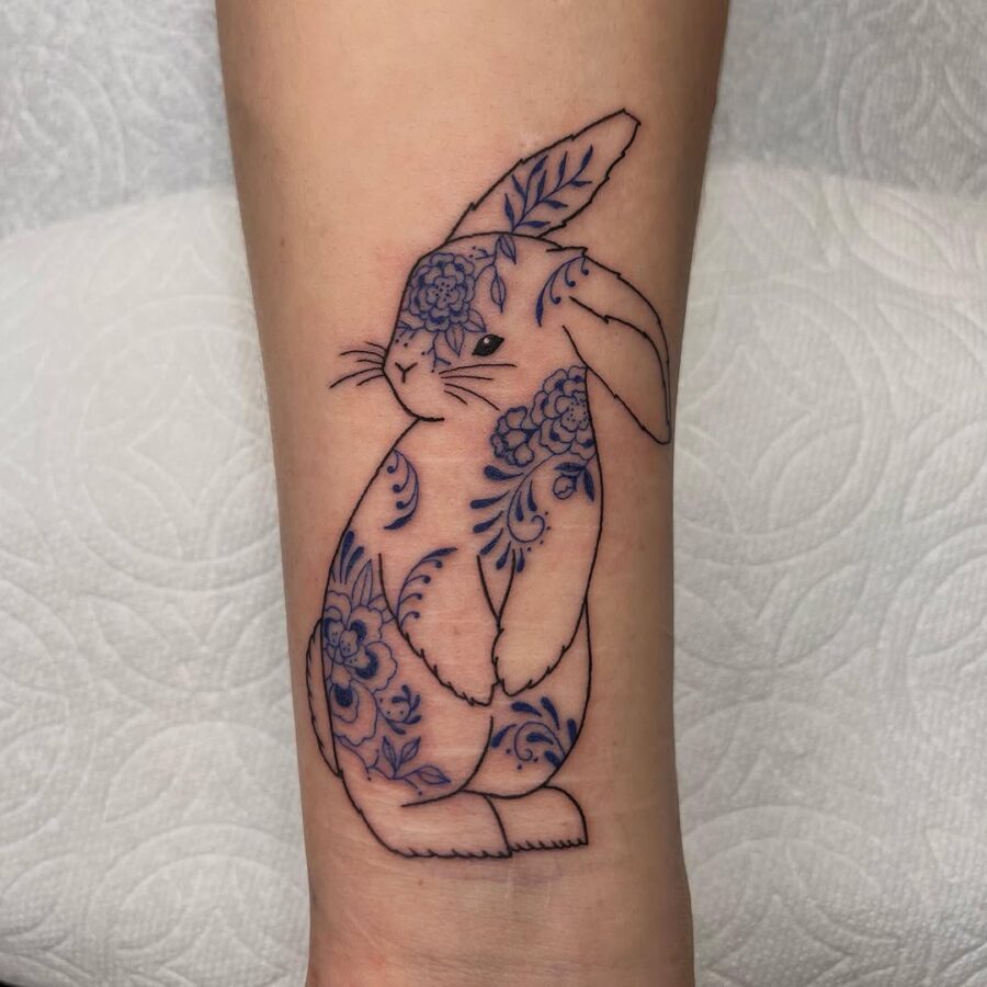 Whimsical rabbit tattoo with floral elements Tattoo on skin