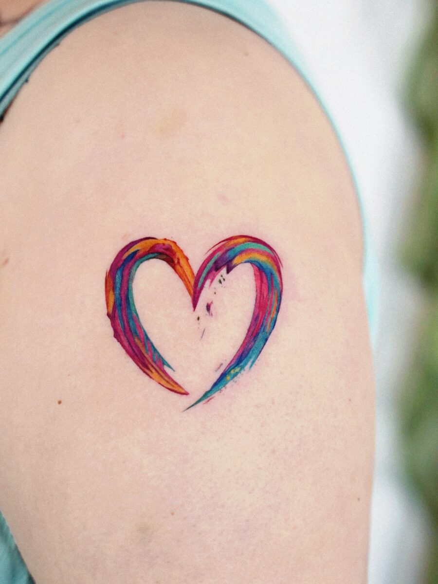 A vibrant heart tattoo celebrating rainbow babies Tattoo on skin