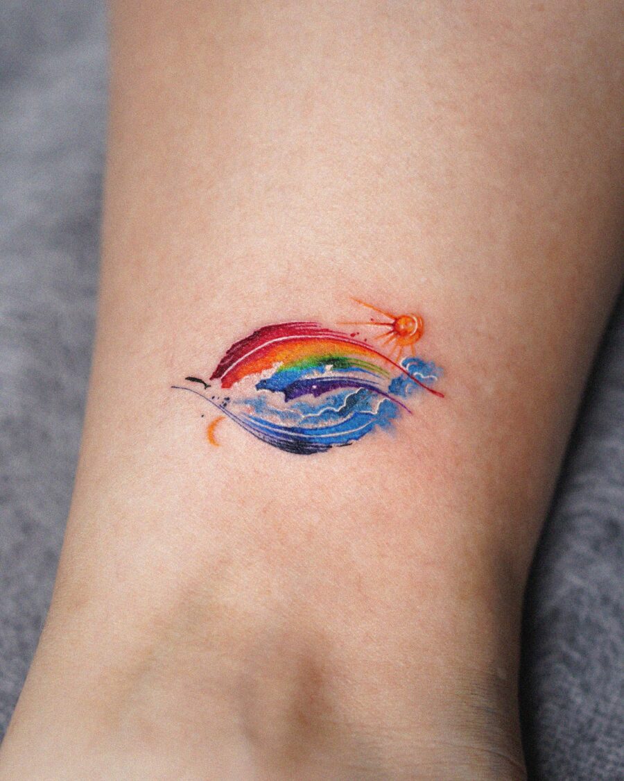 A vibrant rainbow baby tattoo with sun motif Tattoo on skin