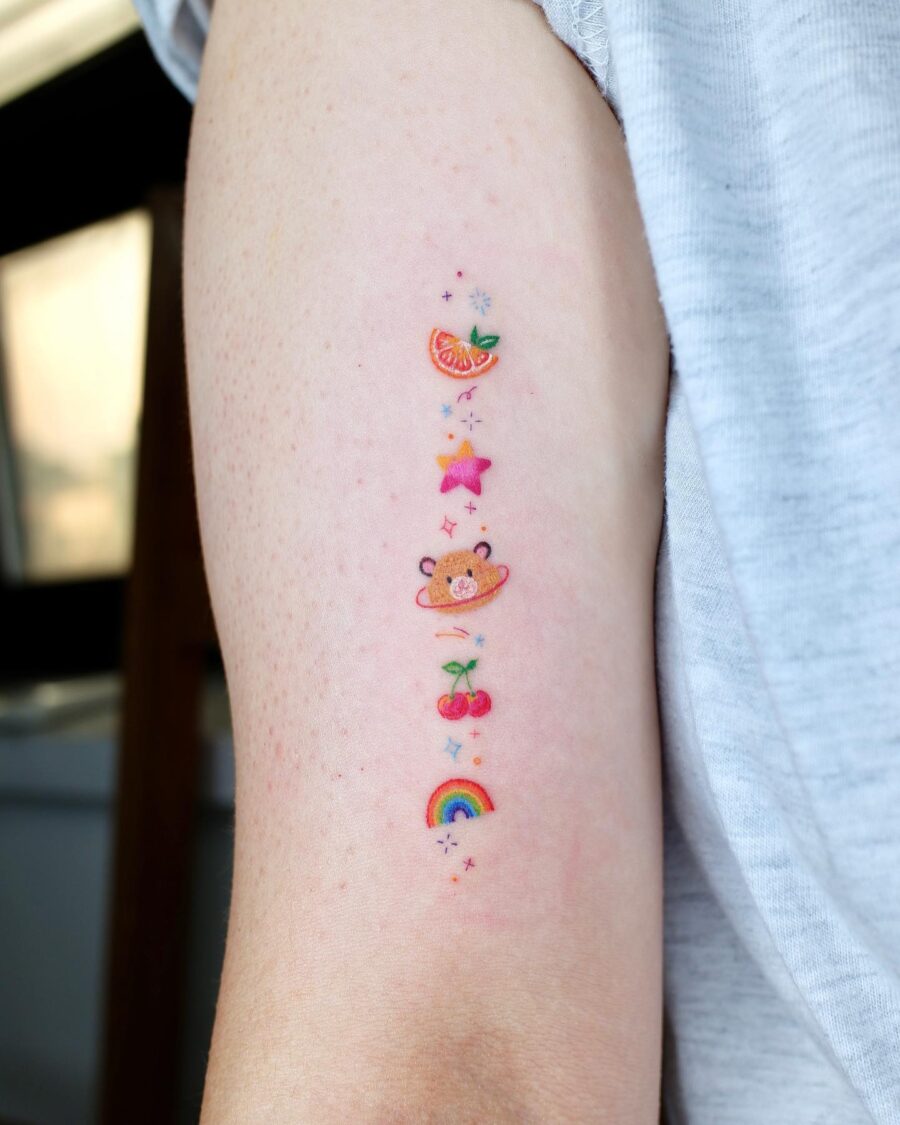 Charming rainbow baby tattoo with playful elements Tattoo on skin
