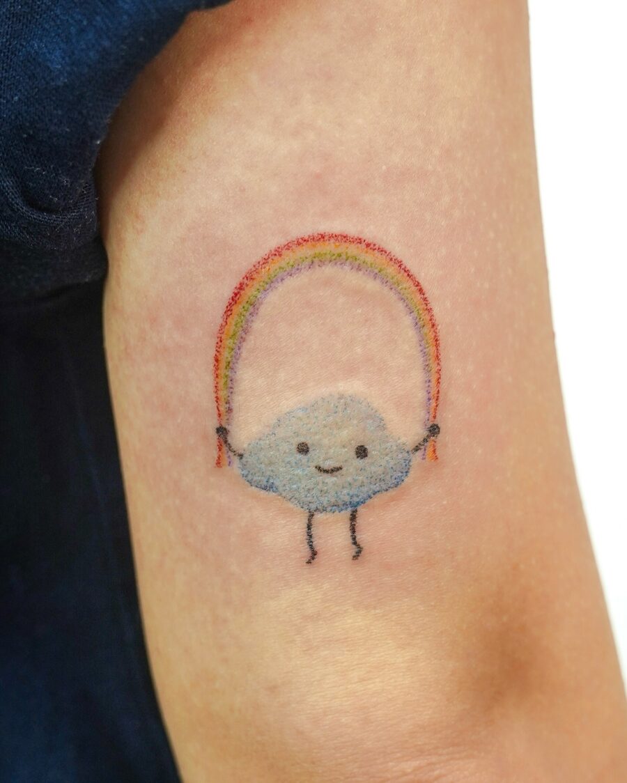 Playful cloud holding a vibrant rainbow Tattoo on skin