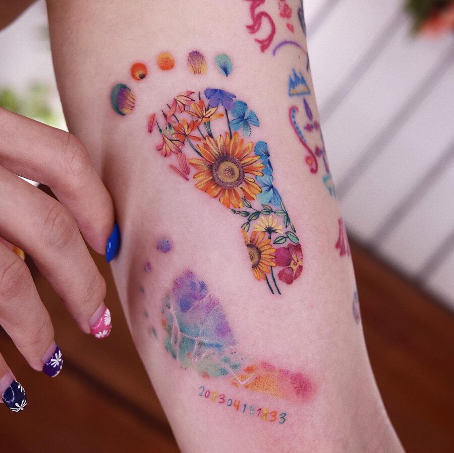 Vibrant rainbow baby footprints tattoo design Tattoo on skin