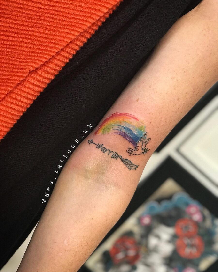 Vibrant rainbow baby tattoo with arrow design Tattoo on skin