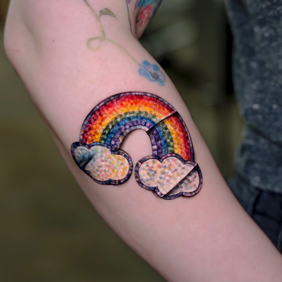 Vibrant rainbow baby tattoo with clouds Tattoo on skin