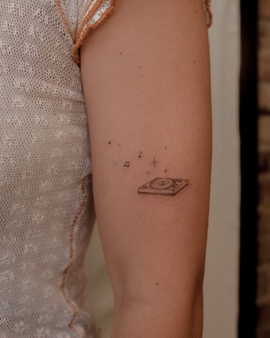 Charming record player tattoo with musical notes Tattoo on skin