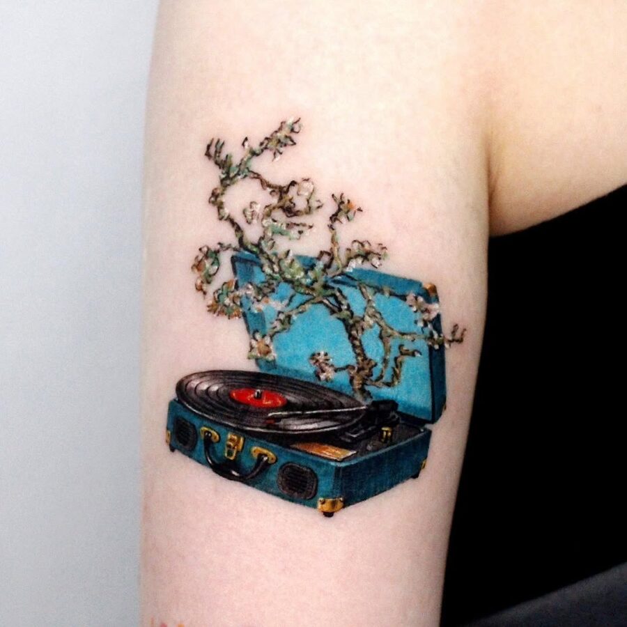 Elegant tattoo of a record player with blossoms Tattoo on skin