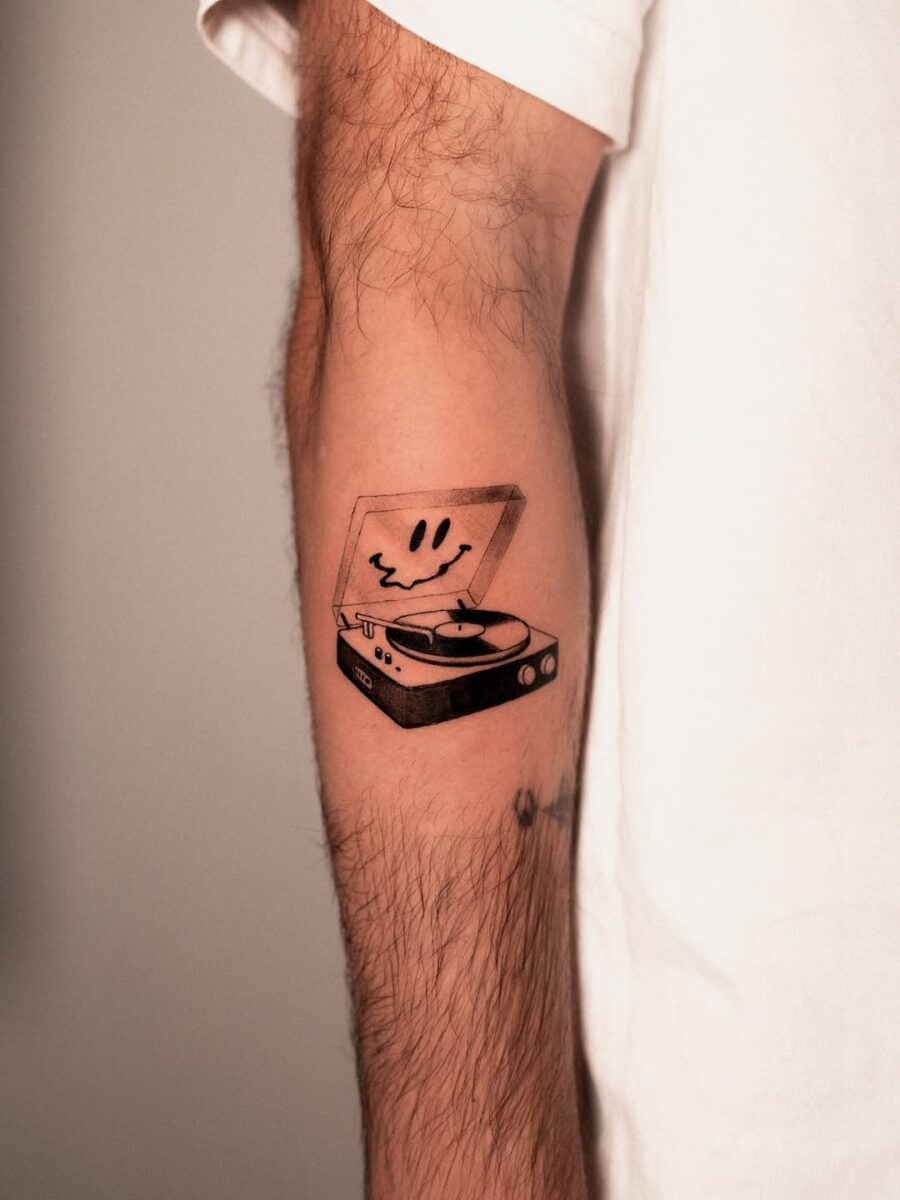 Playful record player tattoo with a smiley face Tattoo on skin