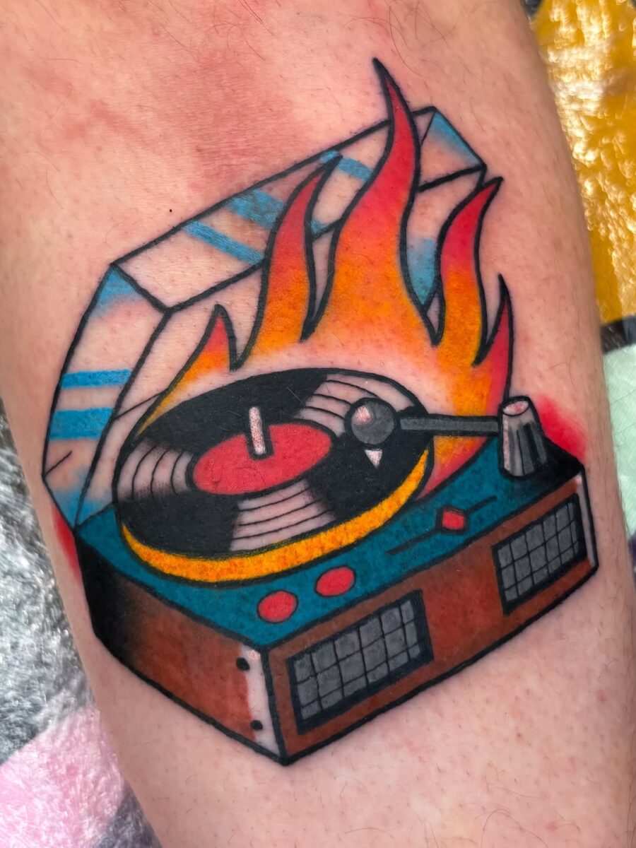 Vivid record player tattoo with fiery flair Tattoo on skin