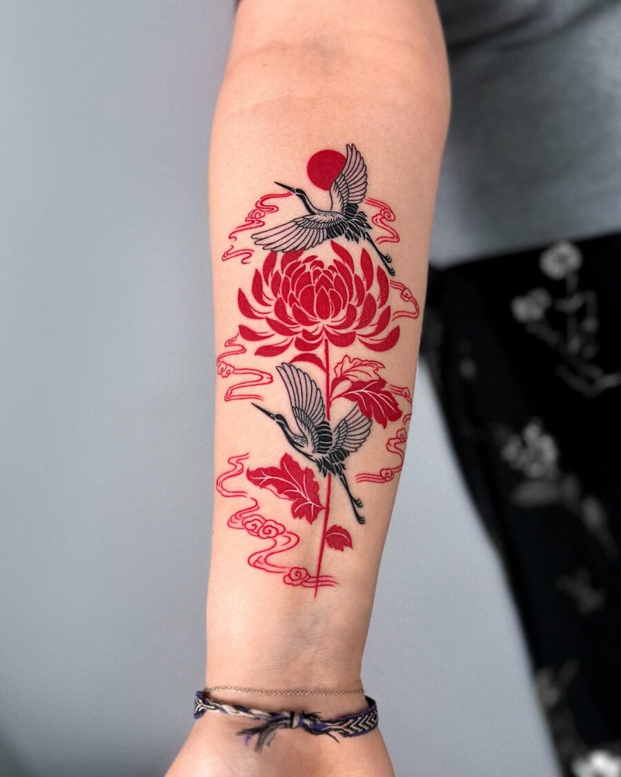 Elegant red ink tattoo featuring cranes and blooms Tattoo on skin