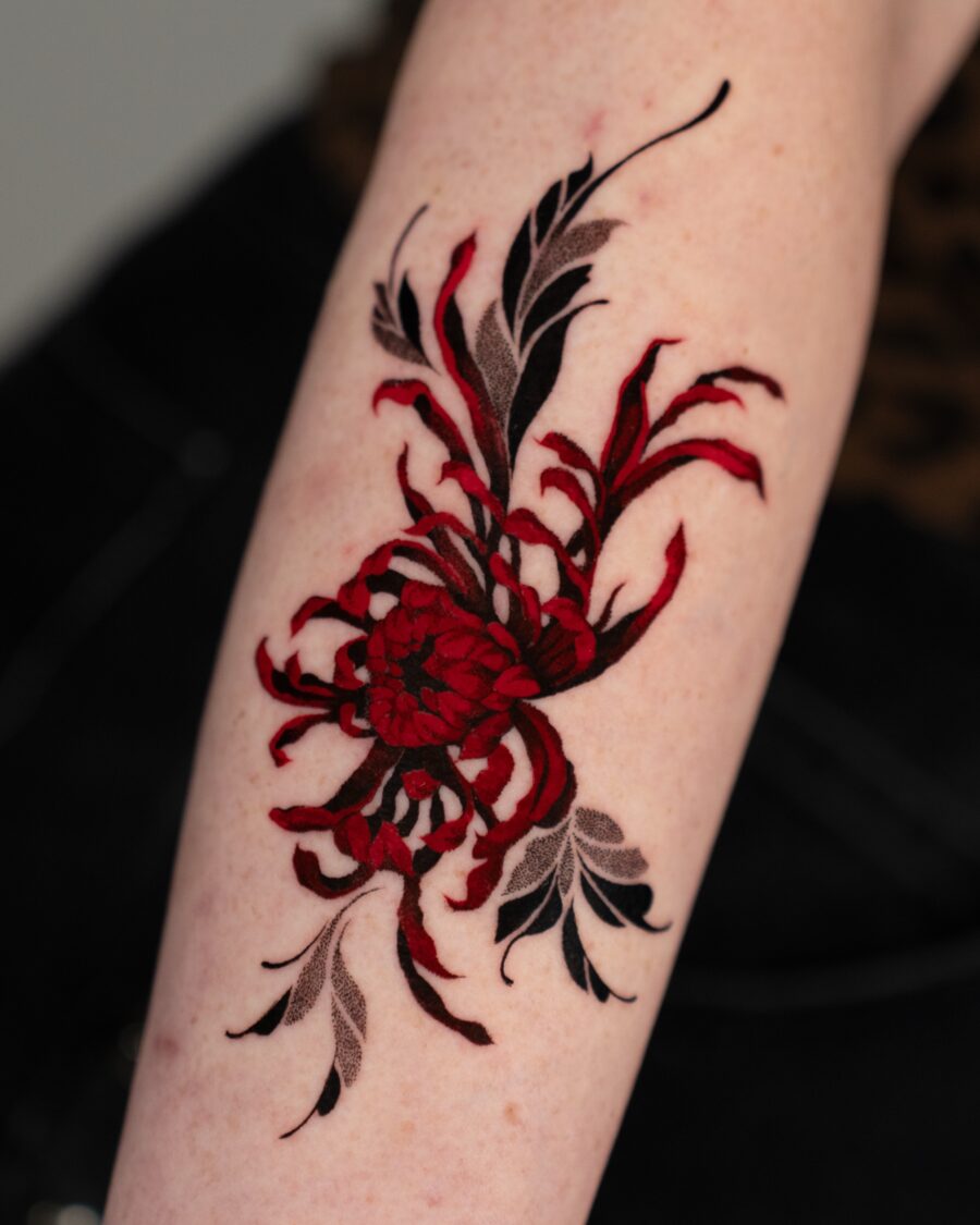Intricate red floral design tattoo on arm Tattoo on skin