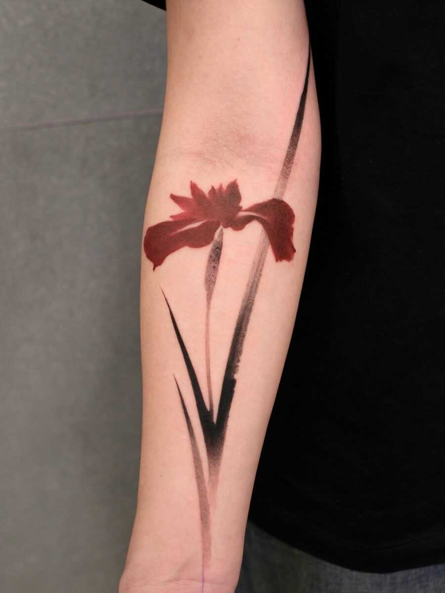 Striking red ink floral tattoo on the arm Tattoo on skin