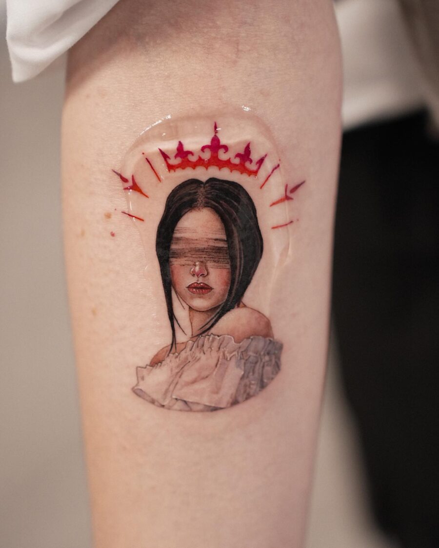 Striking Red Ink Portrait with Crown Detail Tattoo on skin