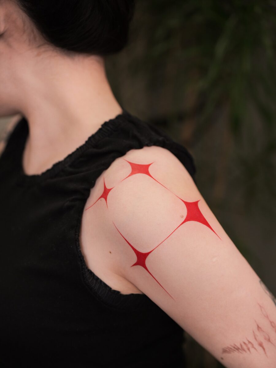 Striking Red Ink Tattoo Design on Shoulder Tattoo on skin