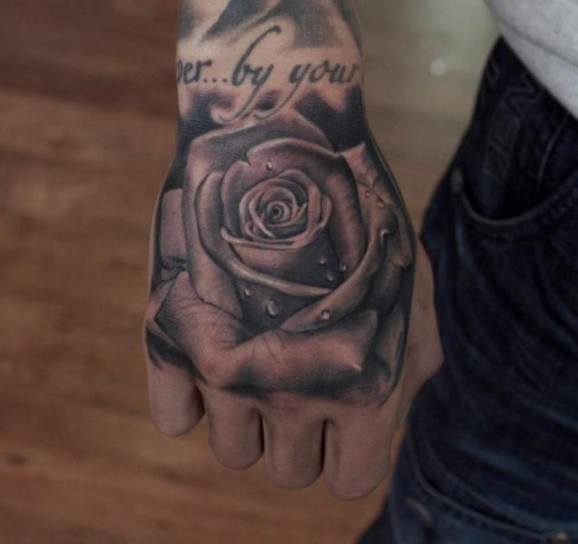 Detailed Uni-colored Rose Tattoo On A Guys Fist Tattoo on skin
